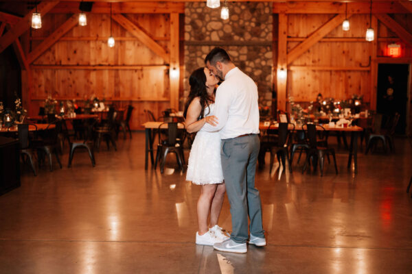 Bride and groom having their last dance and sharing a kiss alone in the events pavilion.