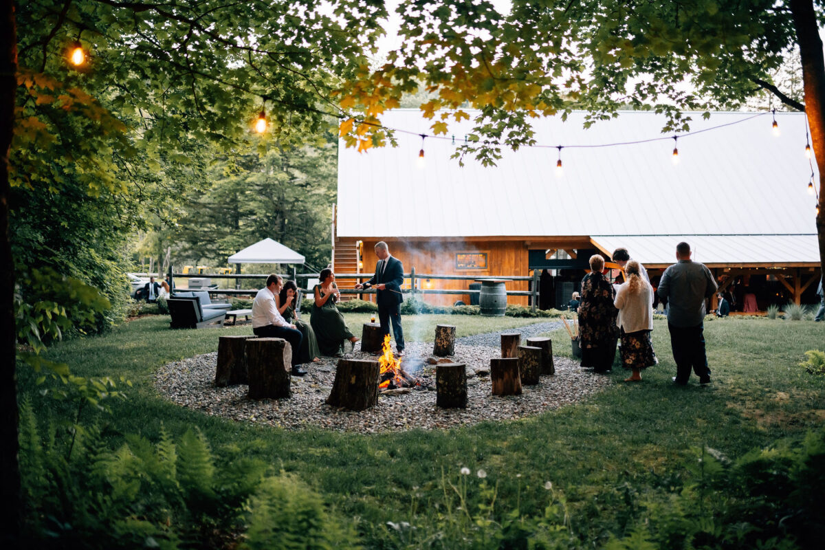 Daytime fire pit. Guests are mingling and enjoying the smores bar.