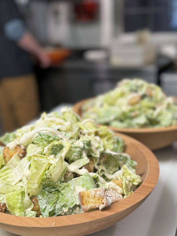 Caesar salads in large family style bowls for the buffet