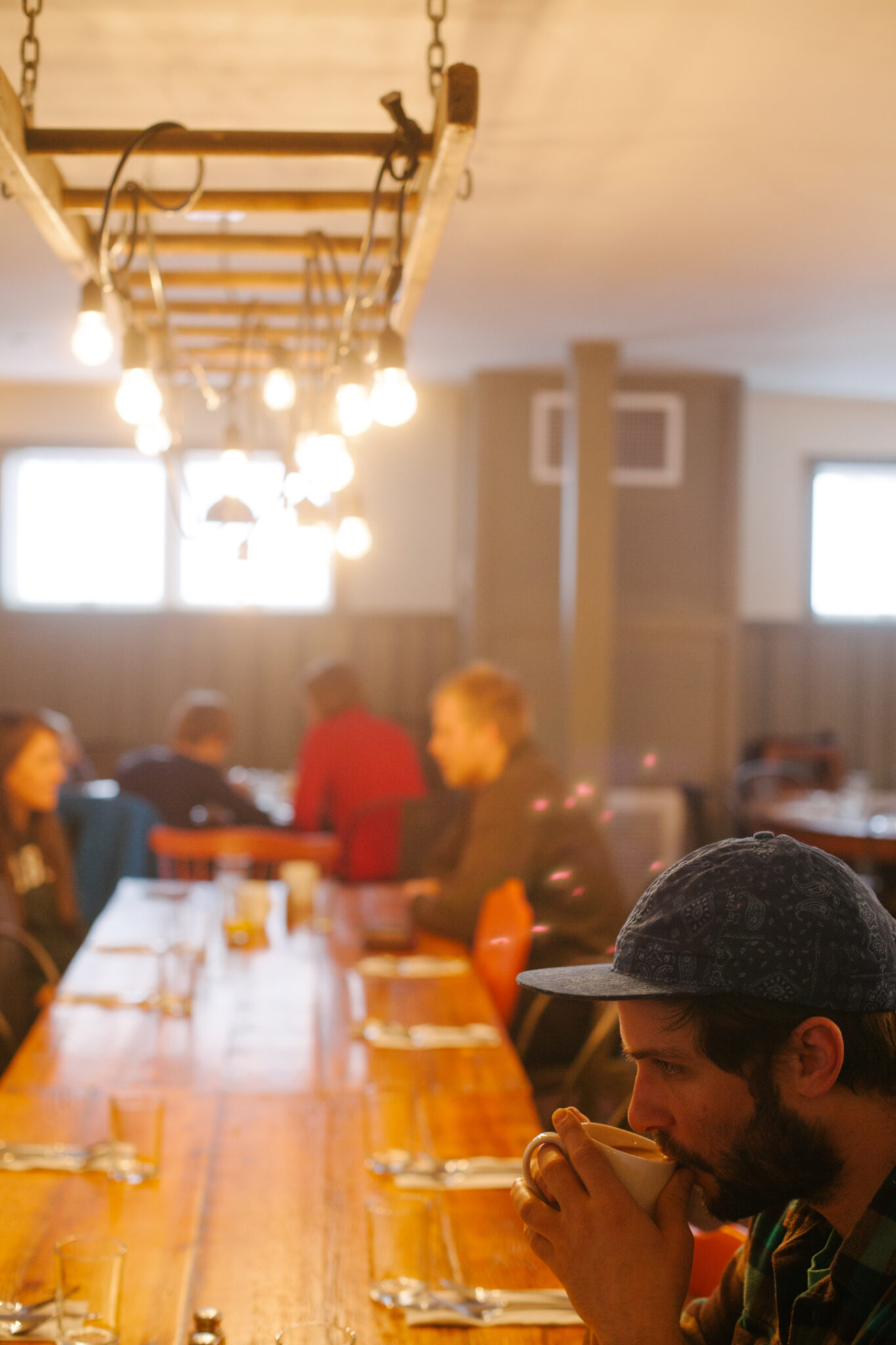 A man sips coffee in the downstairs dining room at the Mad River Barn in Waitsfield, VT